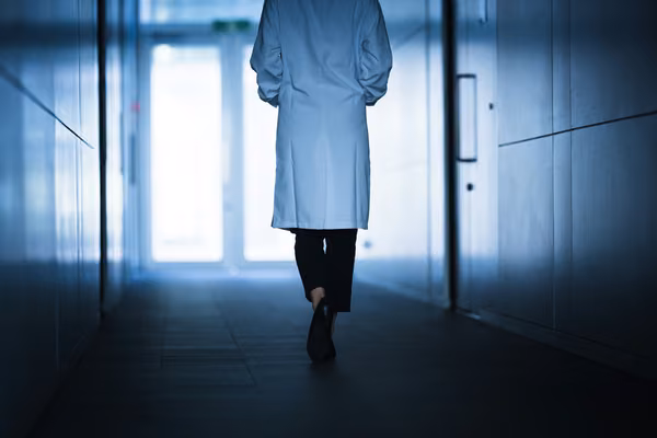 Health professional walking down hospital corridor