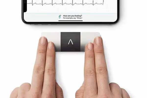 A pair of hands using a Kardiamobile ECG machine to measure heart rate