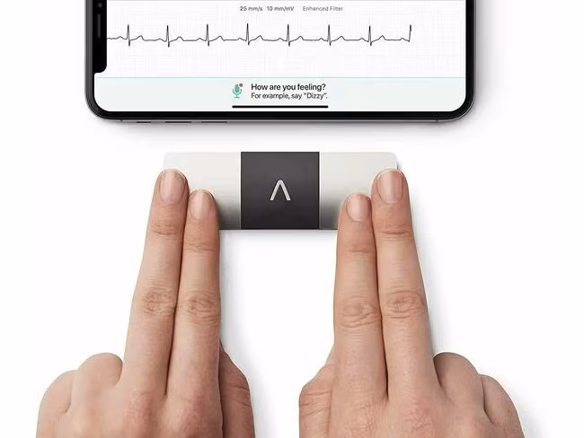 A pair of hands using a Kardiamobile ECG machine to measure heart rate